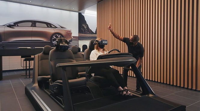 a salesman pitching to the customer wearing a VIVE headset in a simulated car