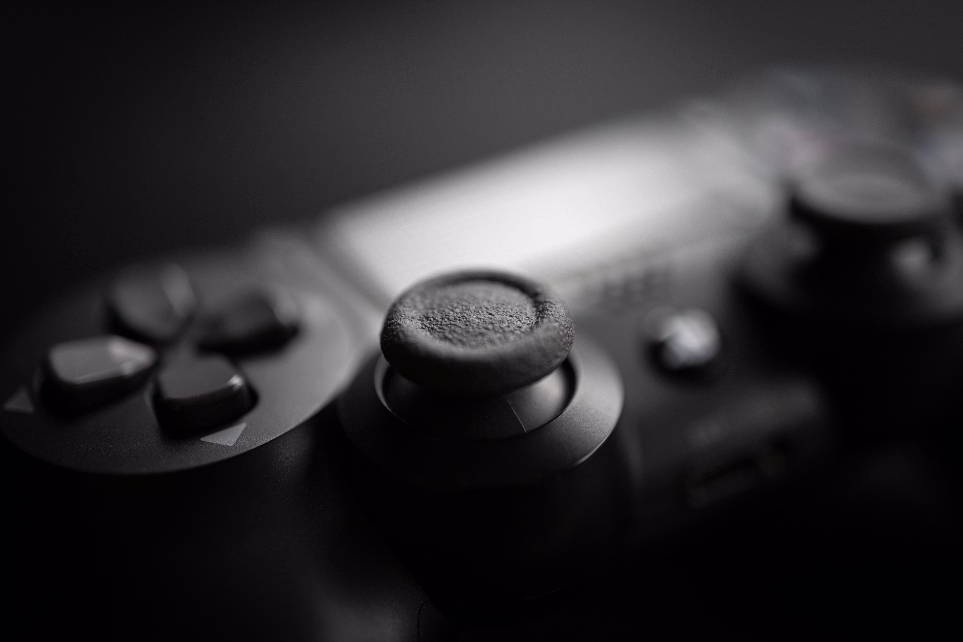 Close-up of a black gaming controller on a dark surface, illustrating console hardware cycles in next-gen gaming