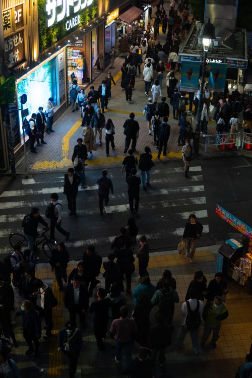 Vibrant Shibuya street crossing in Tokyo at night with crowds and neon billboards